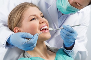 A dentist cleaning a female patient’s teeth