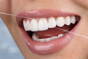 A woman flossing her teeth