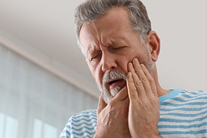 Older man holding jaw