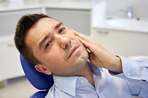 Man holding jaw in pain