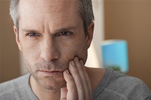 Man in pain holding jaw