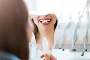 Woman looking at smile in mirror