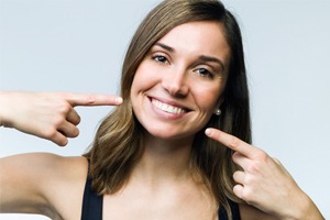 A young woman pointing at her smile